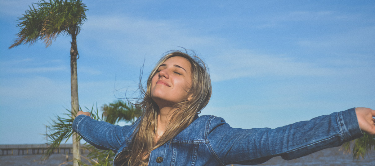 A girl enjoying the breeze at what appears contextually to be a beach